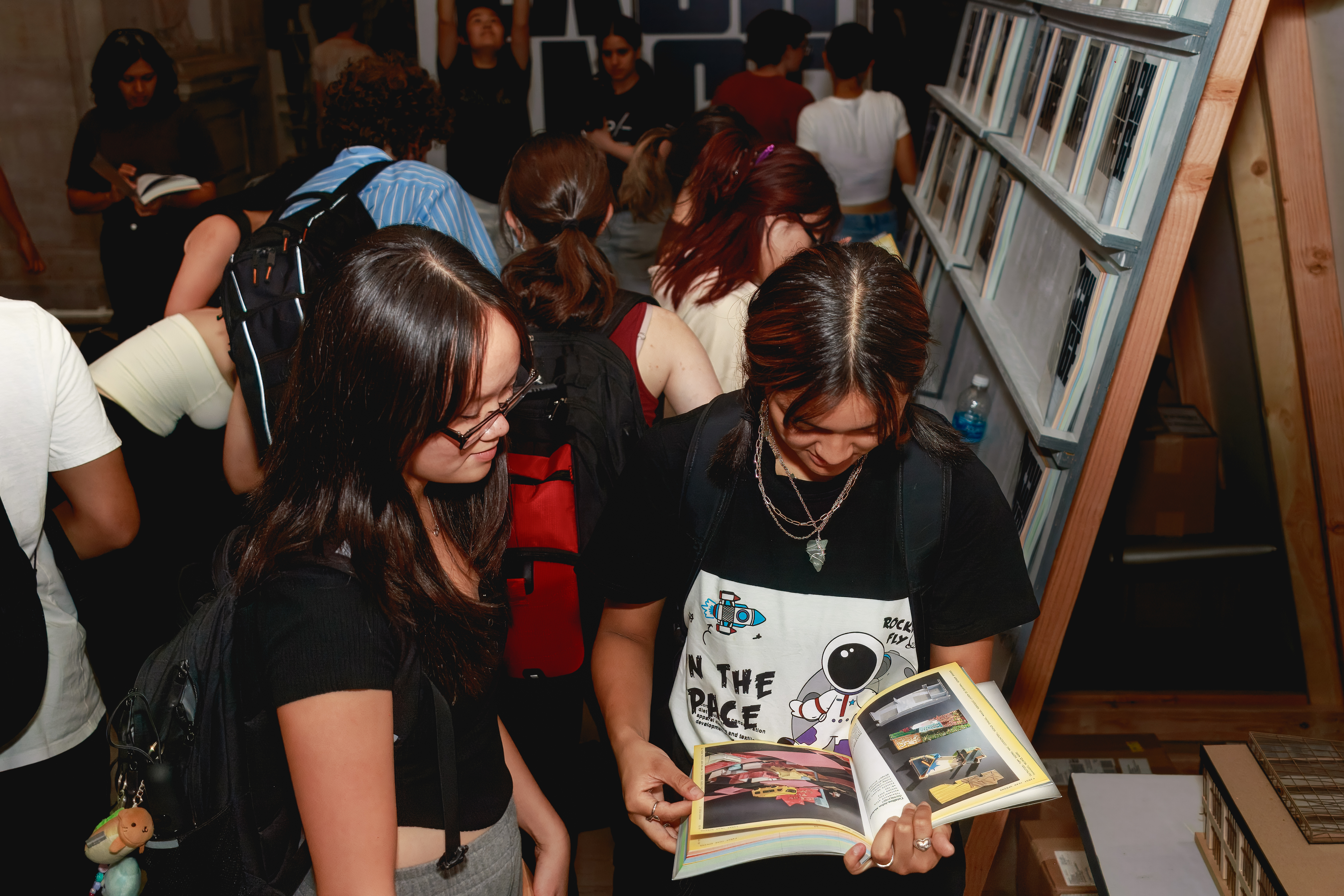 Students check out the 2023 EX-CHANGE catalog at the exhibition. Credit: Long Q Hong