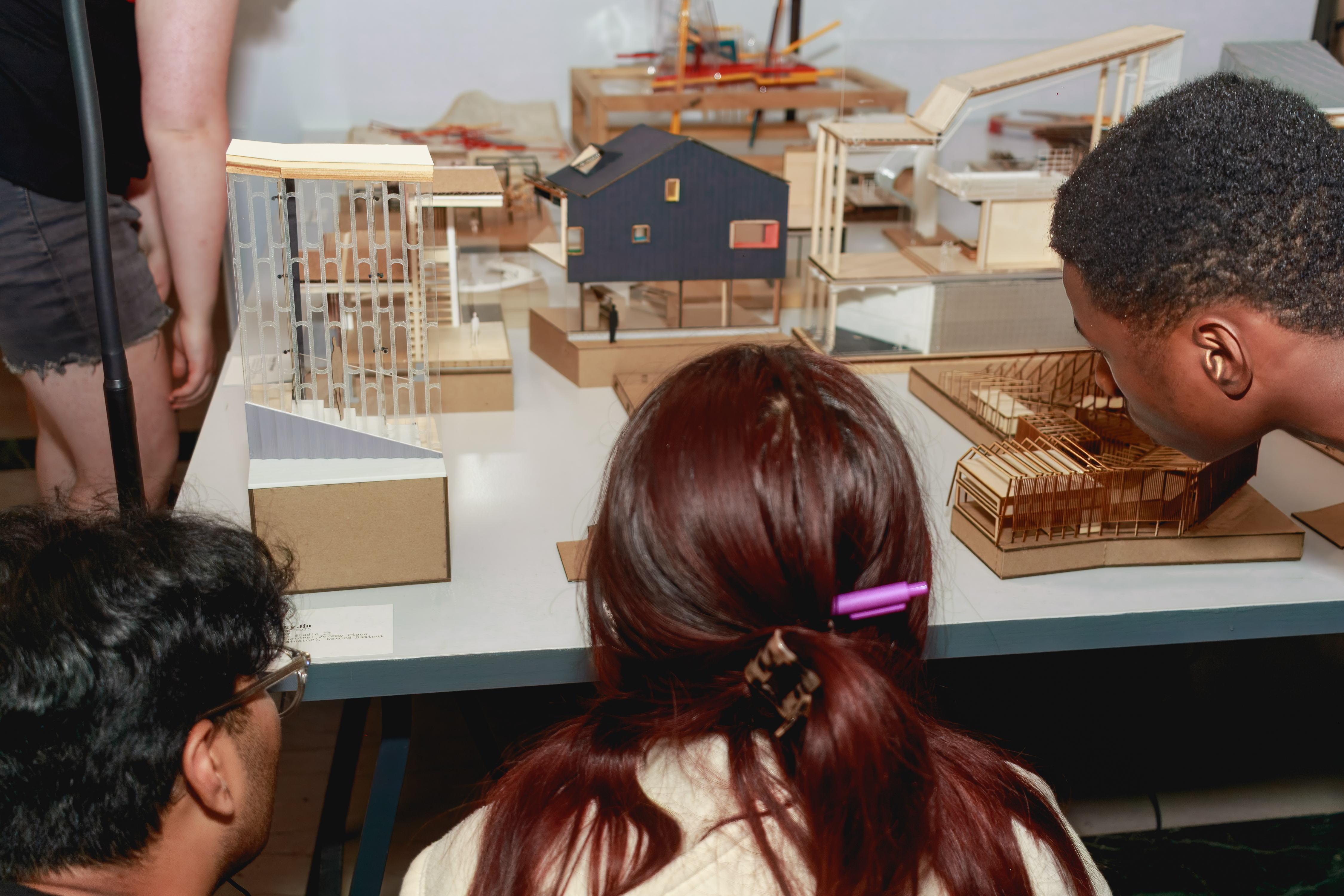 students look at models on a table at the EX-CHANGE exhibition