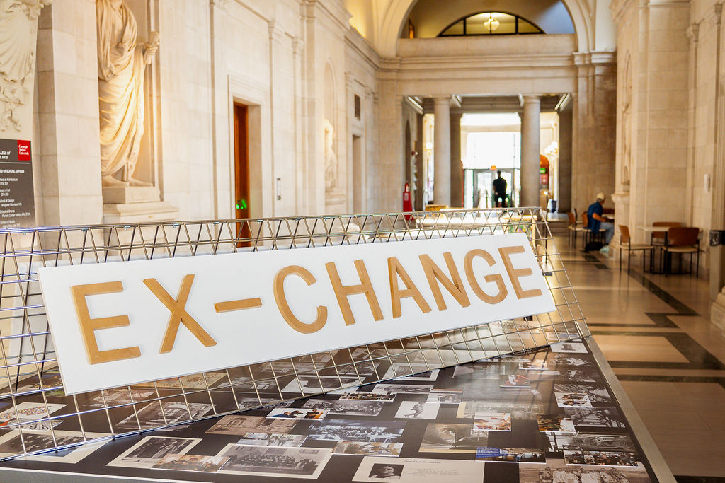 The centerfold table displays the exhibition title and archival photographs from CM-A.