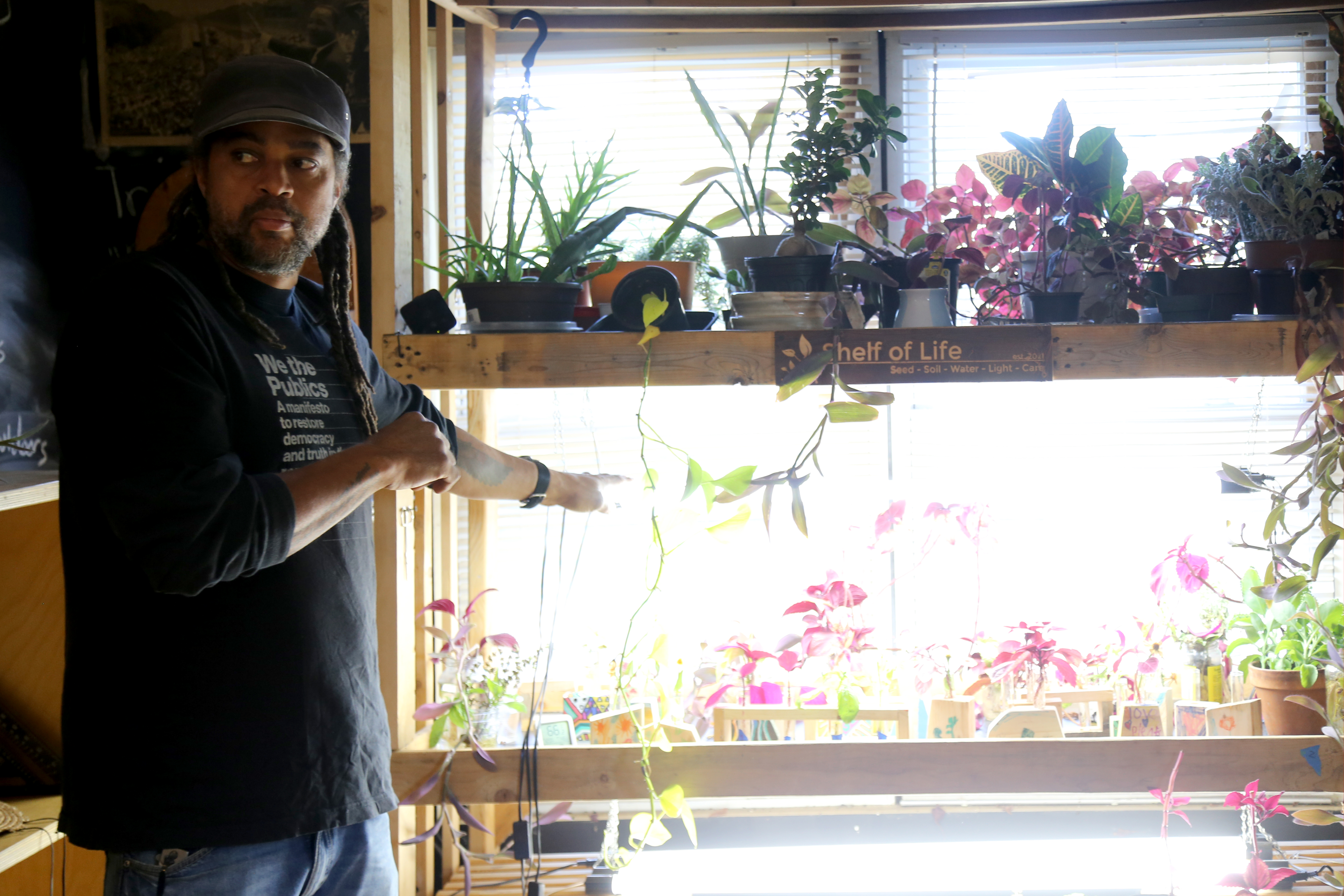 Emmanuel Pratt stands in front of plants