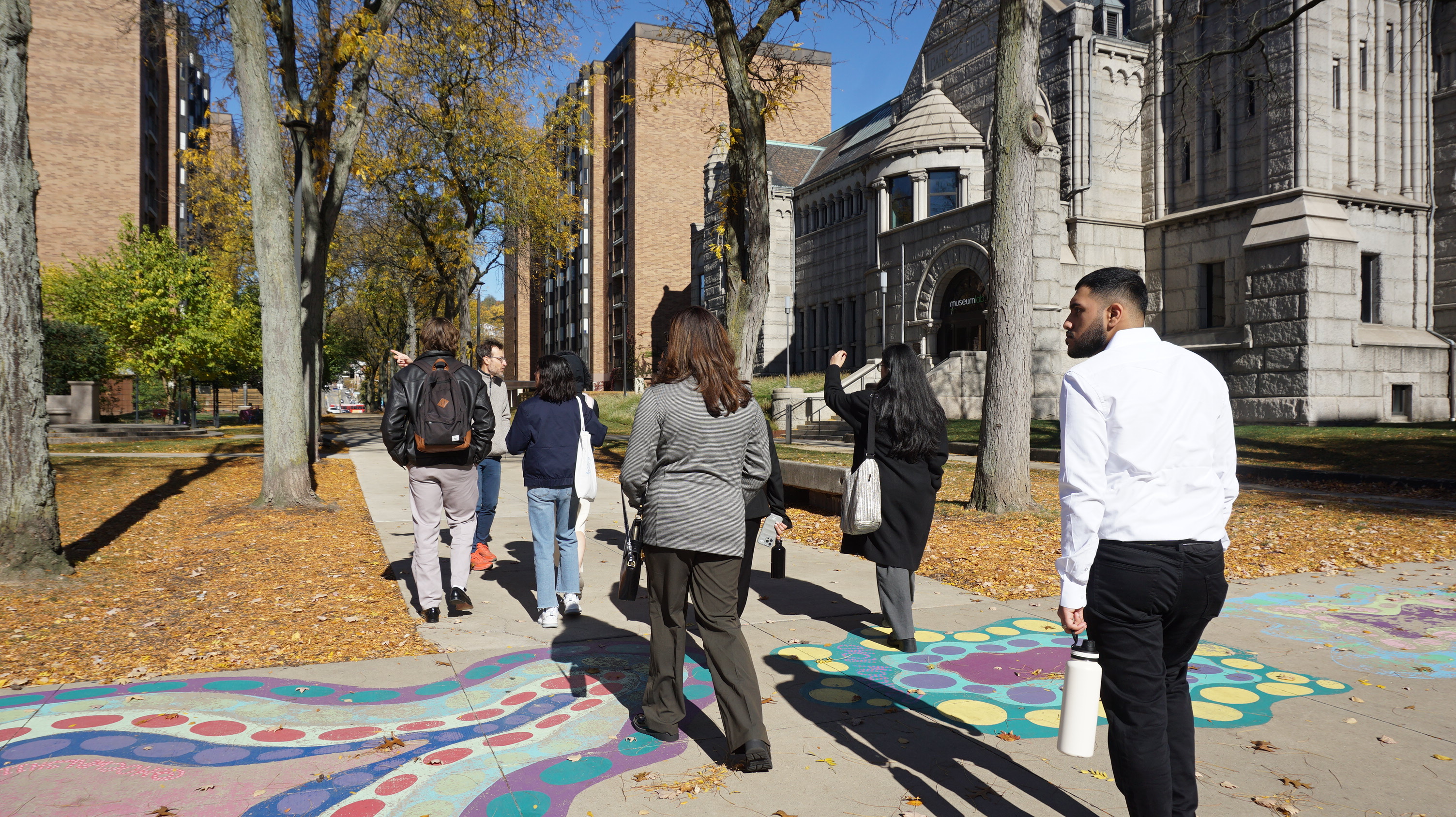 a group of people walk past buildings