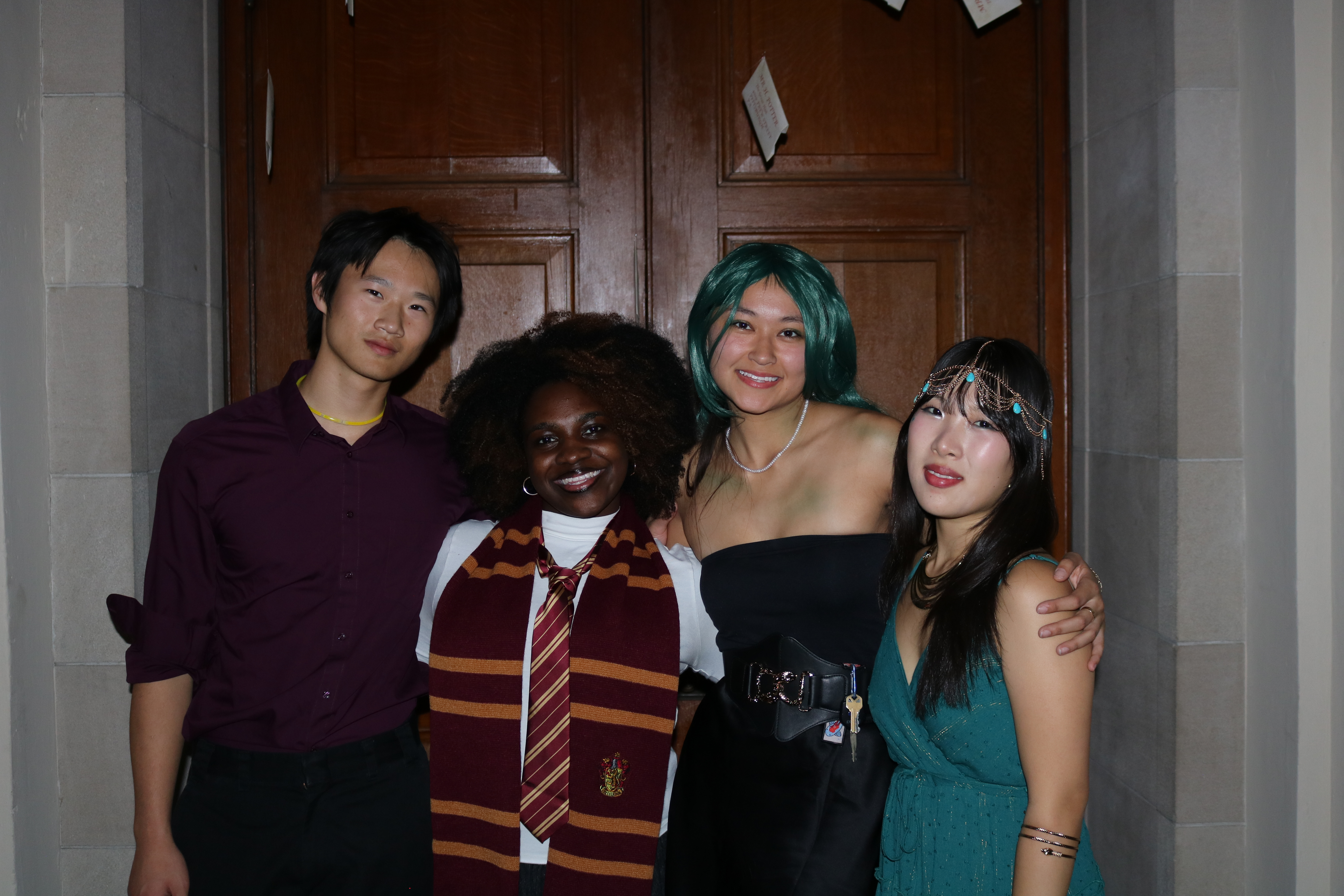 four students in costume pose for a picture