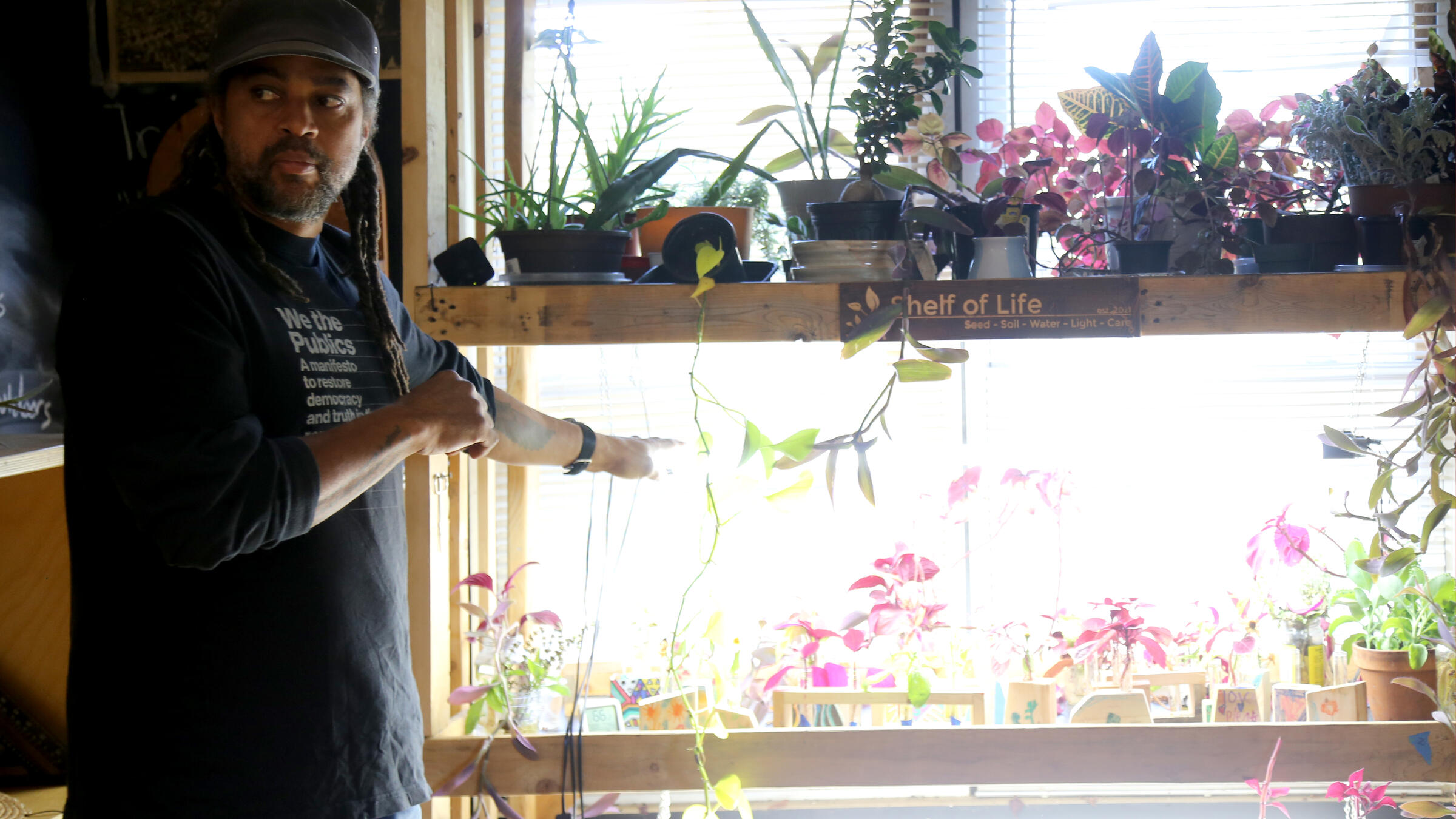 Emmanuel Pratt stands in front of plants