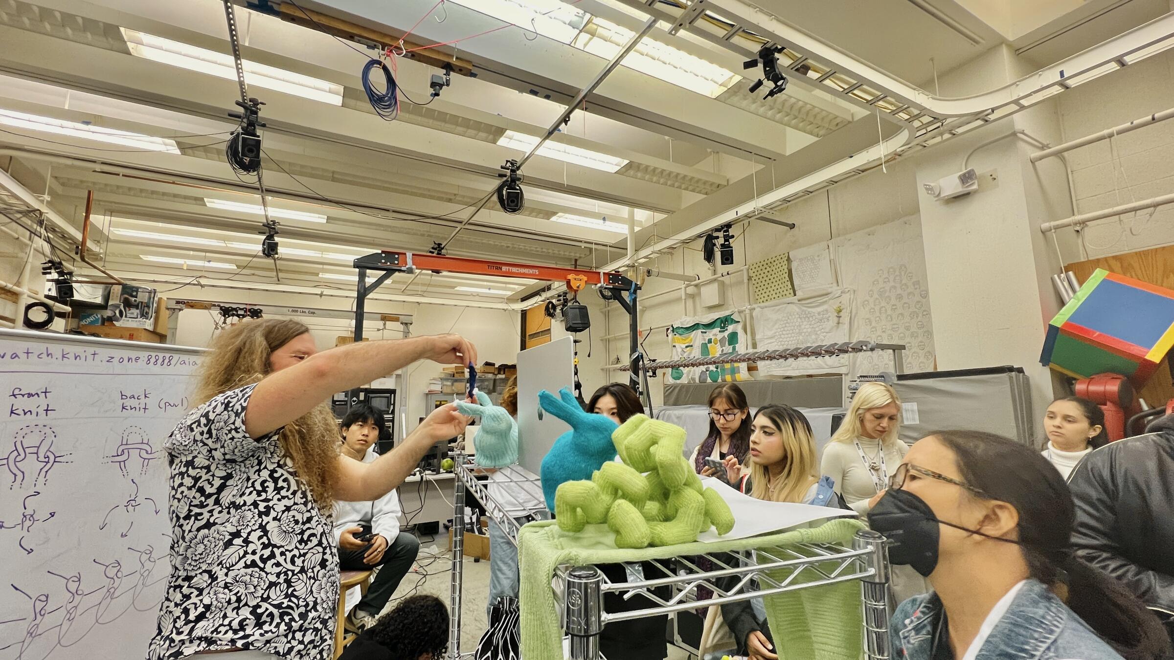 people gathering around woven textiles in a lab setting