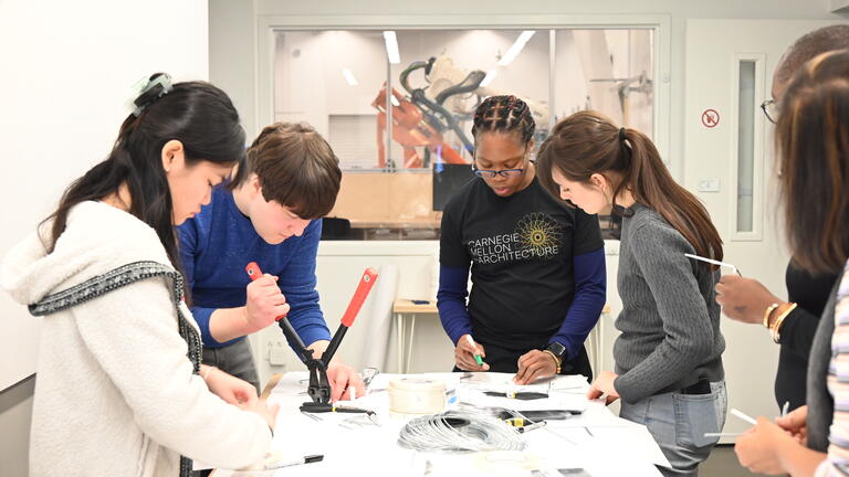 Small group around a table collaborating on a robotics project.