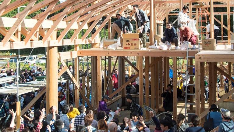 Building site celebration with workers throwing Mochi.