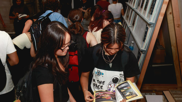 Students check out the 2023 EX-CHANGE catalog at the exhibition. Credit: Long Q Hong