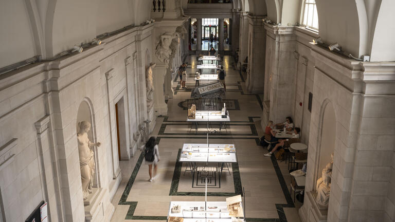 Overhead image of the EX-CHANGE Exhibition showing tables with student work from CM-A studios and courses.