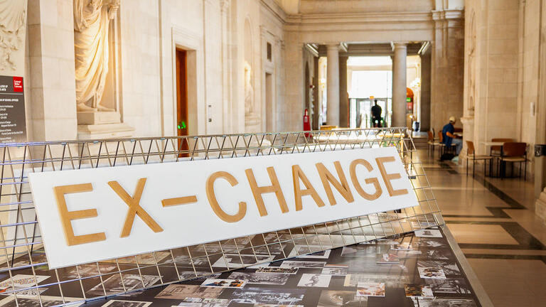 The centerfold table displays the exhibition title and archival photographs from CM-A.