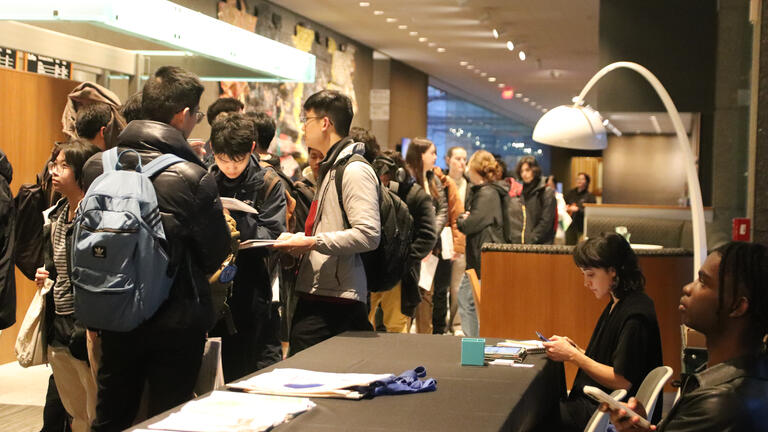 a line of students waits to get into a lecture