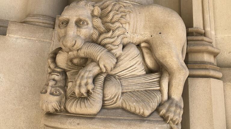 stone carving of a lion biting a person's arm