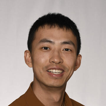 headshot photo of a person in a brown collared shirt