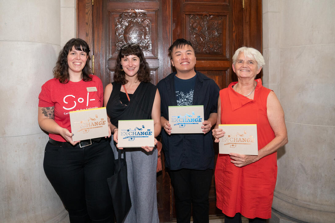 Four people pose with books