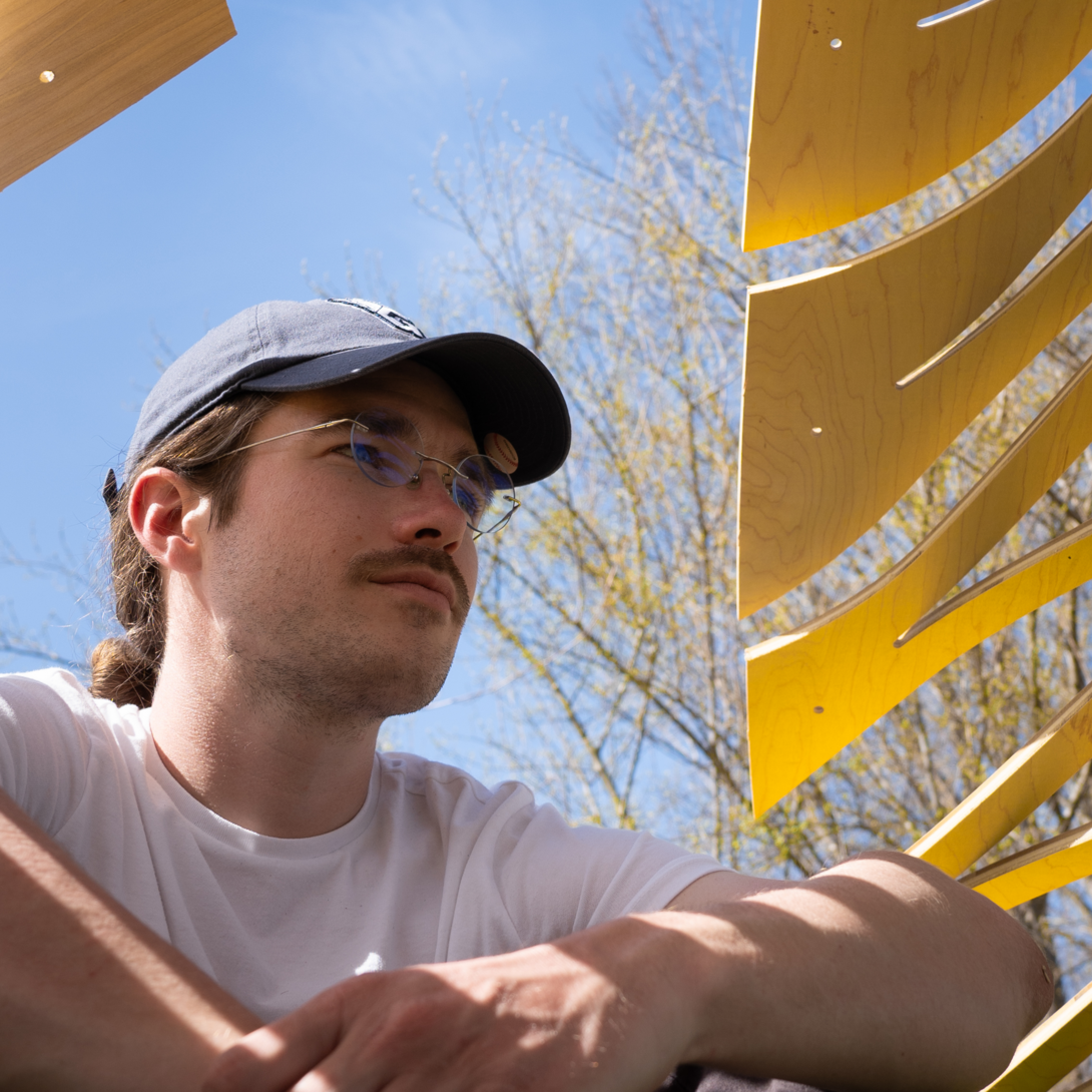 person with glasses wearing a hat and white t-shirt