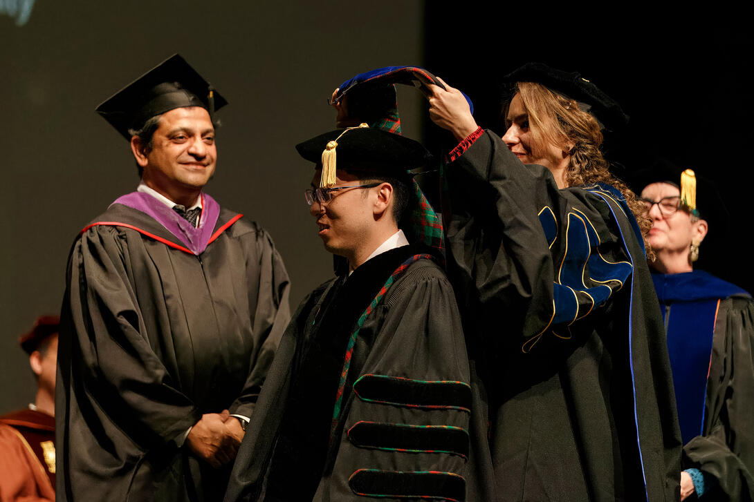 a faculty member participates in a PhD hooding during the Architecture graduation ceremony Credit: Long Q Hong